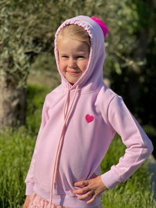 Girl in pink hoodie with heart and bobble